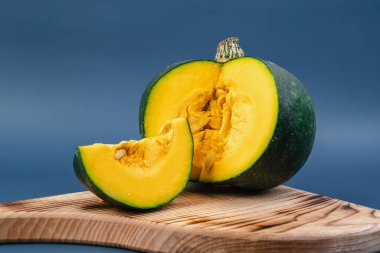 Mor arka planda bir balkabağı. Sonbahar kompozisyonu. Sağlıklı vejetaryen yemekleri.