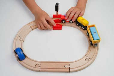 Çocuk oyuncak ahşap yolda oynuyor. Üst Manzara. Çocuk odasında oyuncak trenle oynuyor..
