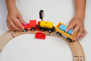 Çocuk oyuncak ahşap yolda oynuyor. Üst Manzara. Çocuk odasında oyuncak trenle oynuyor..