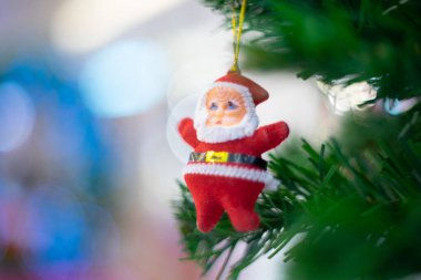 Noel Baba bebeği ellerinde asılı duruyor. 