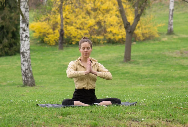 Yoga girl in lotus pose in green park — Stock Photo, Image