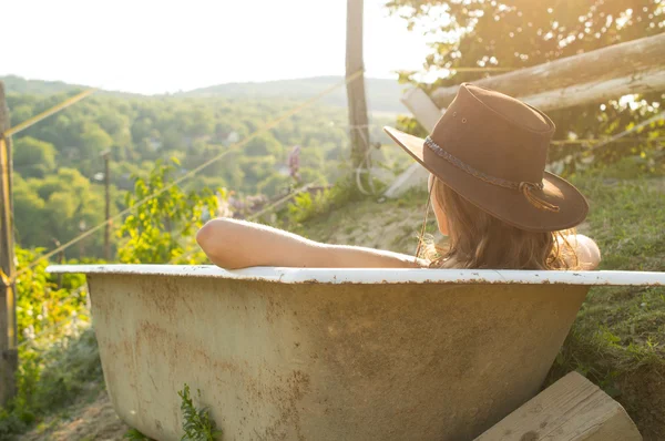 Sexy cowgirl sedí v lázni na ranči — Stock fotografie