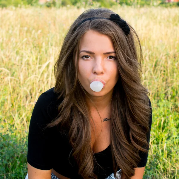 Bela menina adolescente inflando bolha de chiclete — Fotografia de Stock