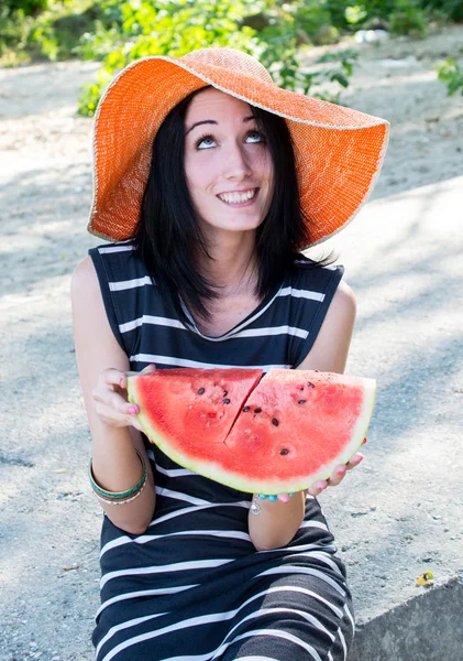 Beautiful girl eating fresh watermelon in big hat — Stock Photo, Image