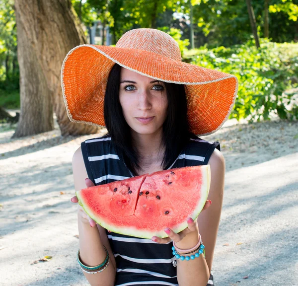 Menina bonita comendo melancia fresca em chapéu grande — Fotografia de Stock