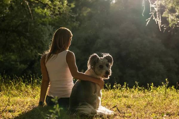 Woman enjoying summer with funny dog in nature