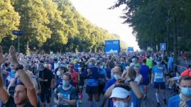 Başlangıç koridorundaki Berlin Maratonu katılımcıları, ana koşucu kitlesinden önce başlayan daha hızlı koşucuların başlamasını memnuniyetle karşılıyor. COVID-19 yüzünden katılımcılar maske takmaya başlamalı.. 