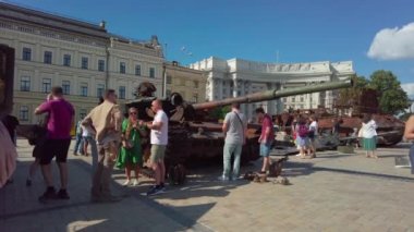 Kyiv, Ukraine - July 24, 2022: People look a burned-out Russian tank that was destroyed in Ukraine after the Russian invasion in February 2022.