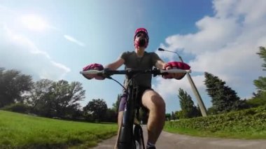 Young man in protective helmet ride on bicycle sunny summer day. Low angle view. 