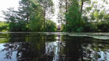A woman with a fishing rod sits on the shore and looks at a float