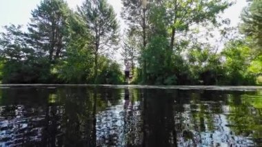 A woman casts a fishing rod on a sunny summer day.