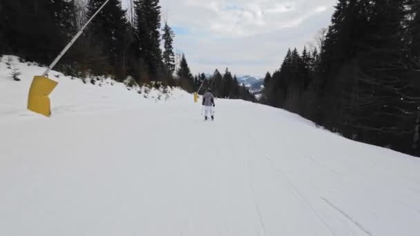 리조트에서 휴가를 보내는 여자가 스키를 산비탈을 내려가고 있습니다 — 비디오