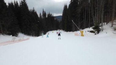 Bir kadın, diğer kayakçılardan daha güzel bir yamaçta kayak yapıyor.