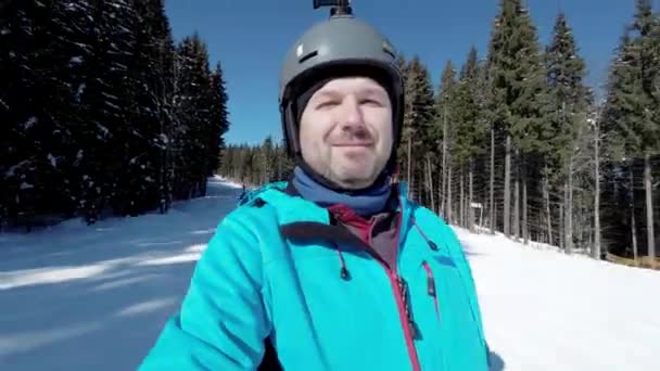 スキーをしながら街の斜面を滑り降りる男 — ストック動画