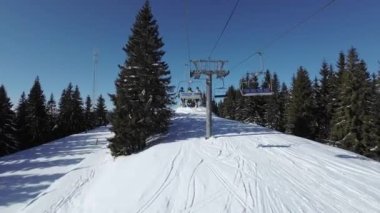 Güneşli bir günde kayak asansörünün birinci şahıs görüntüsü. 