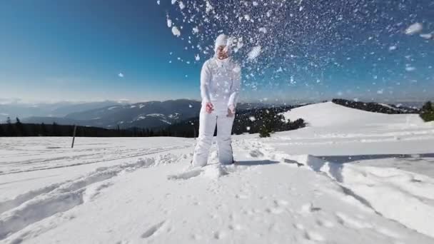 Vrouw Het Wit Gooit Sneeuw Een Zonnige Winterdag — Stockvideo
