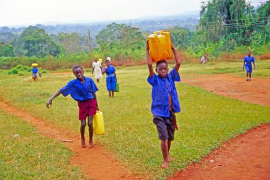 Buikwe bölgesinde çocuklar su taşır, Uganda. Yemek pişirmek için odun ve su getir. Onlar sadece çocuk..