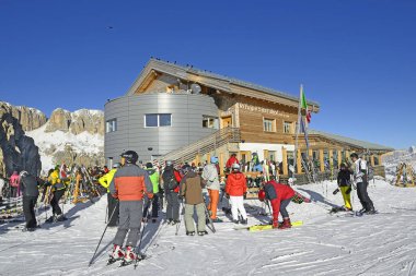 DOLOMITES, GÜNEY TİROL, İTALYA - Val Gardena 'daki Rifugio Saa Bece dağ kulübesinin önündeki kayakçılar. Dolomitler kayak arazileriyle ünlüdür..