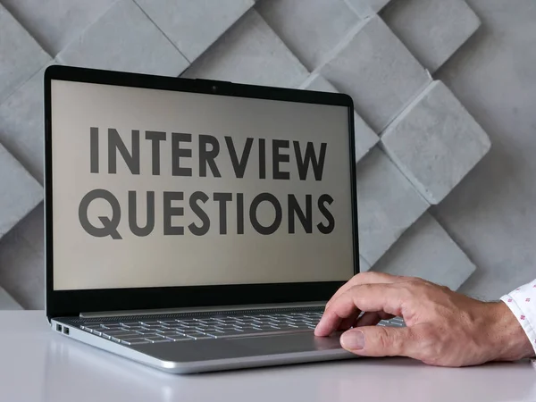 El hombre lee las preguntas de la entrevista en el portátil. —  Fotos de Stock