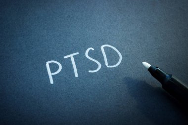 PTSD ya da Post Travma Sonrası Stres Bozukluğu Kara kağıt üzerine elle yazılmış.