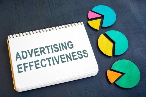 Reclame effectiviteit concept. Notitieblok en kaarten op een donker oppervlak. — Stockfoto