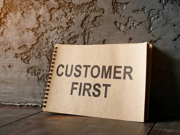 Customer first phrase on the notepad sheet. — Stock Photo, Image