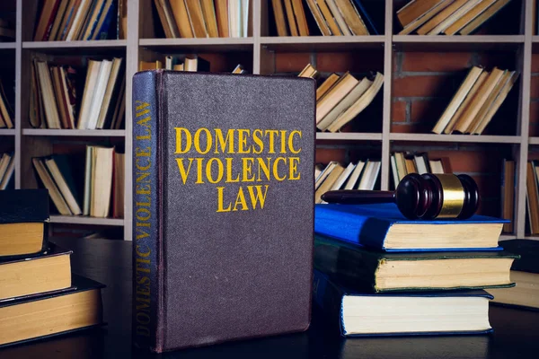 《家庭暴力法》、成堆的书籍和书架. — 图库照片