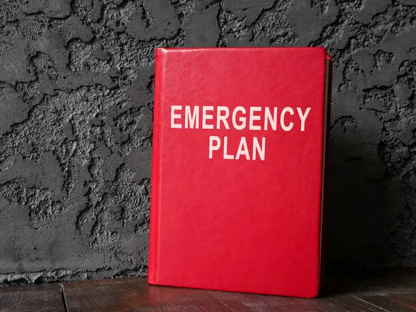 Emergency plan red book near dark wall.