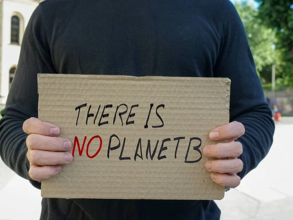 A man holds a poster There is no planet B.