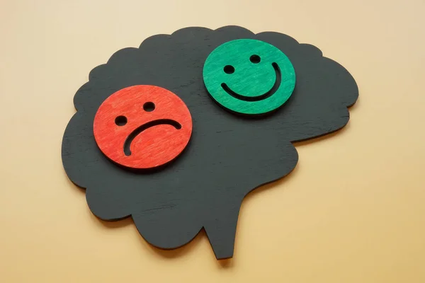 Il concetto di disturbo bipolare. Forma cerebrale con emoticon felici e tristi. — Foto Stock