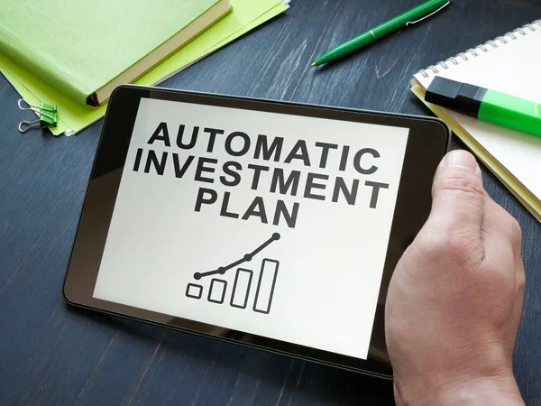 Homme détient plan d'investissement automatique AIP dans la tablette. — Photo