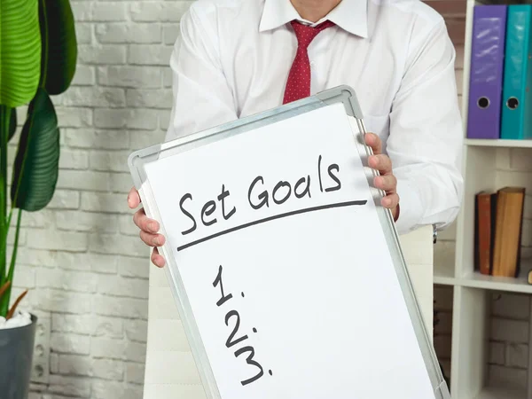 Manager holds board with words Set goals and list. — Stock Photo, Image