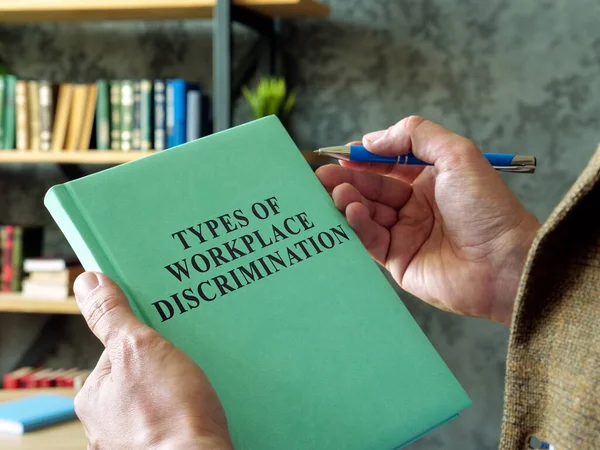 Manager holds book types of workplace discrimination. — Stock Photo, Image