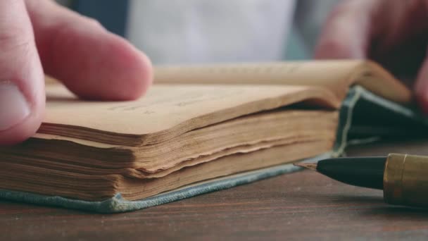 Close-up of a hand turning the pages of an old book. — Stockvideo