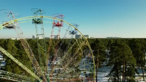 Flying next to an empty old Ferris wheel in a winter park. — Stockvideo