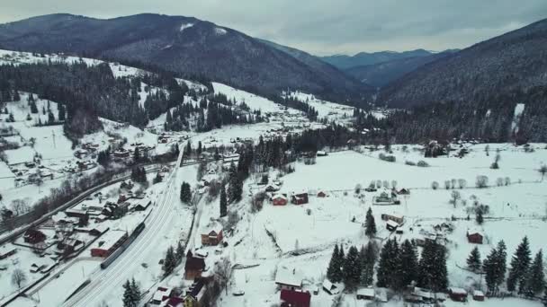 Um vale com uma cidade entre cadeias de montanhas e uma ferrovia. — Vídeo de Stock