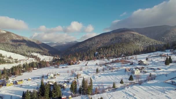 Inverno paisagem montanhosa. Casas cobertas de neve em uma colina, floresta e nuvens. — Vídeo de Stock