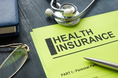 Tahta yüzeyinde steteskop olan sağlık sigortası formu..