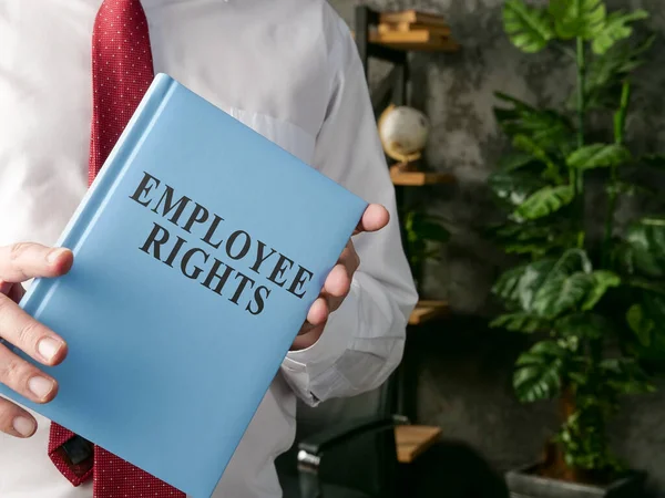 Um gerente que oferece um livro de direitos dos funcionários. — Fotografia de Stock