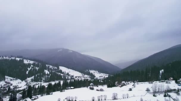 悲観的に、山の中で暗い冬の天気。森の端に家. — ストック動画