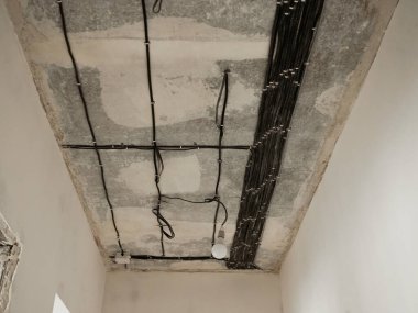 Elektrik kablolarıyla dolu koridor tavanı. Daire tadilatı.