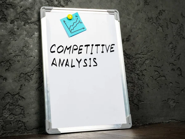 Um quadro branco perto da parede com palavras análise competitiva. — Fotografia de Stock