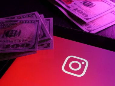 KYIV, UKRAINE - 20 Mart 2022. Instagram para kazanma. Logosu ve parası olan akıllı bir telefon..