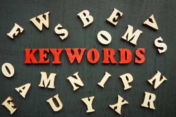 Egy szó kulcsszavak és fa betűk körül. — Stock Fotó