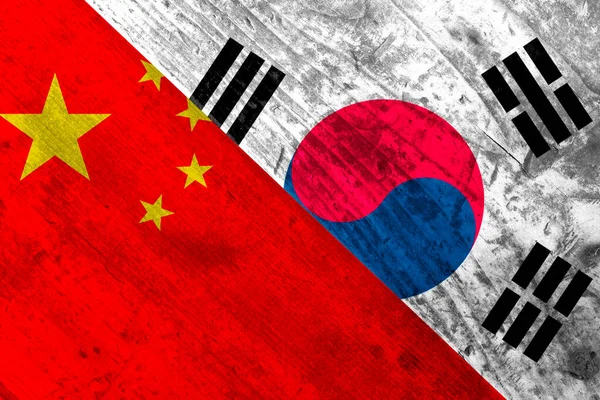 Tahta bir yüzeyde Çin ve Güney Kore bayrakları.