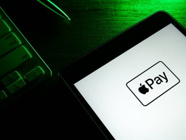 KYIV, UKRAINE - 26 Mayıs 2022. Karanlıkta Apple Pay logosu olan tablet. Yazı.