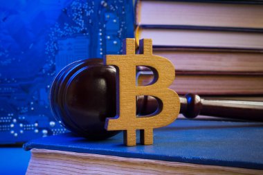 Bitcoin işareti ve kitap üzerindeki tokmak. Kripto para birimi yasası kavramı.