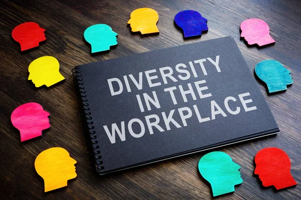 Colored figures and an inscription Diversity in the workplace on notebook.