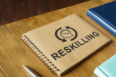 Etrafında kitap ve sözcükler olan bir not defteri..