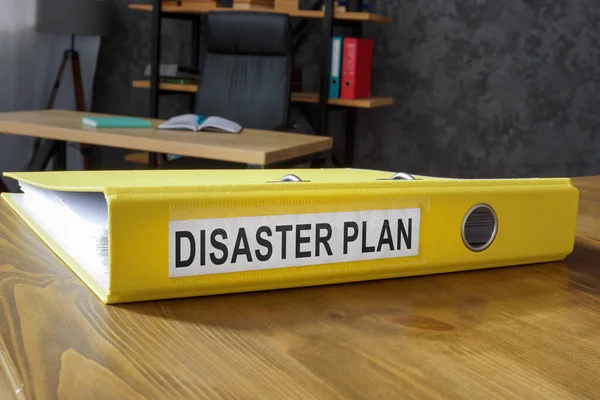Yellow folder with disaster plan in office.